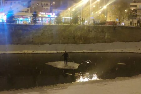 A man used a piece of ice sheet like a raft in Çoruh River, Turkey