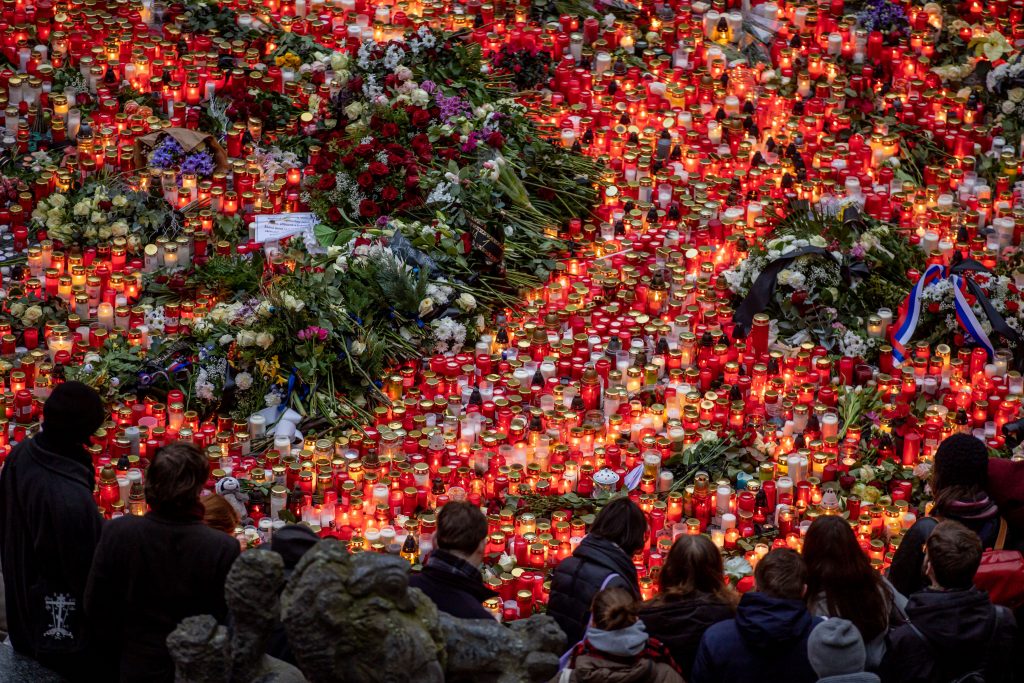 People pay respects a day after a shooting at Charles University in Prague