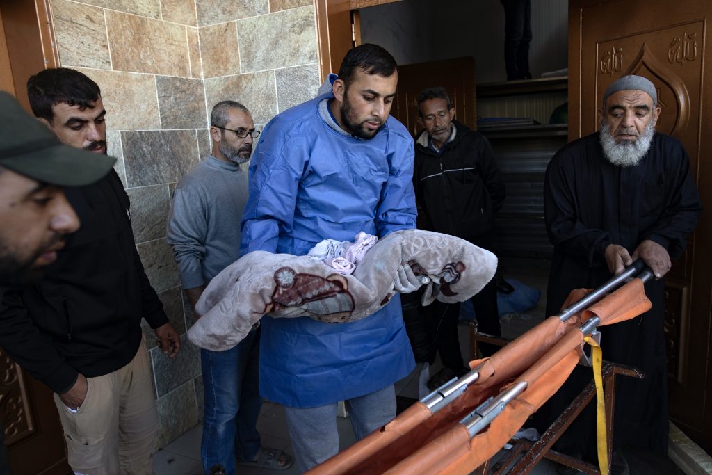 Relatives mourn over the remains of family members killed in Israeli air strike