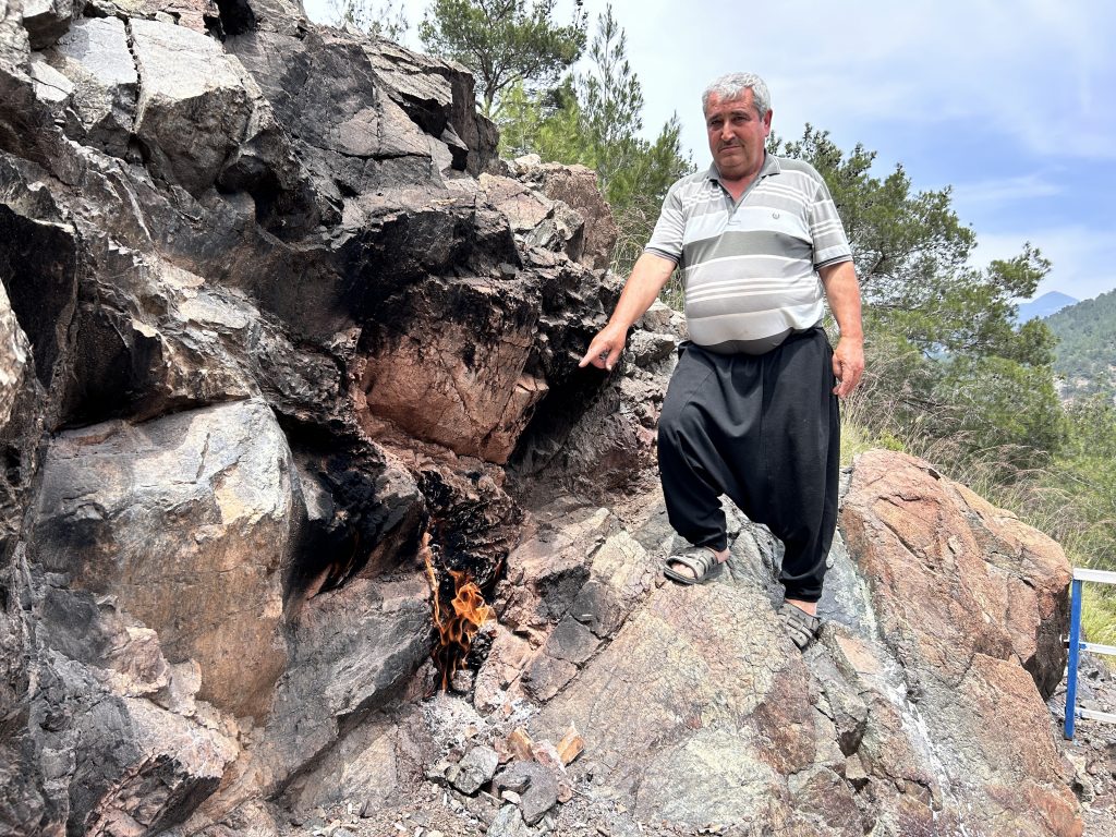 YILLARDIR YANMAYA DEVAM EDEN AMANOS DAĞI ETEĞİNDEKİ TAŞ, İLGİ ÇEKİYOR BÖLGE SAKİNİ MUSTAFA KALE: "BU KÖYDE HİÇ KİMSE YANAN TAŞIN NE ZAMAN YANMAYA BAŞLADIĞINI BİLMEZ"