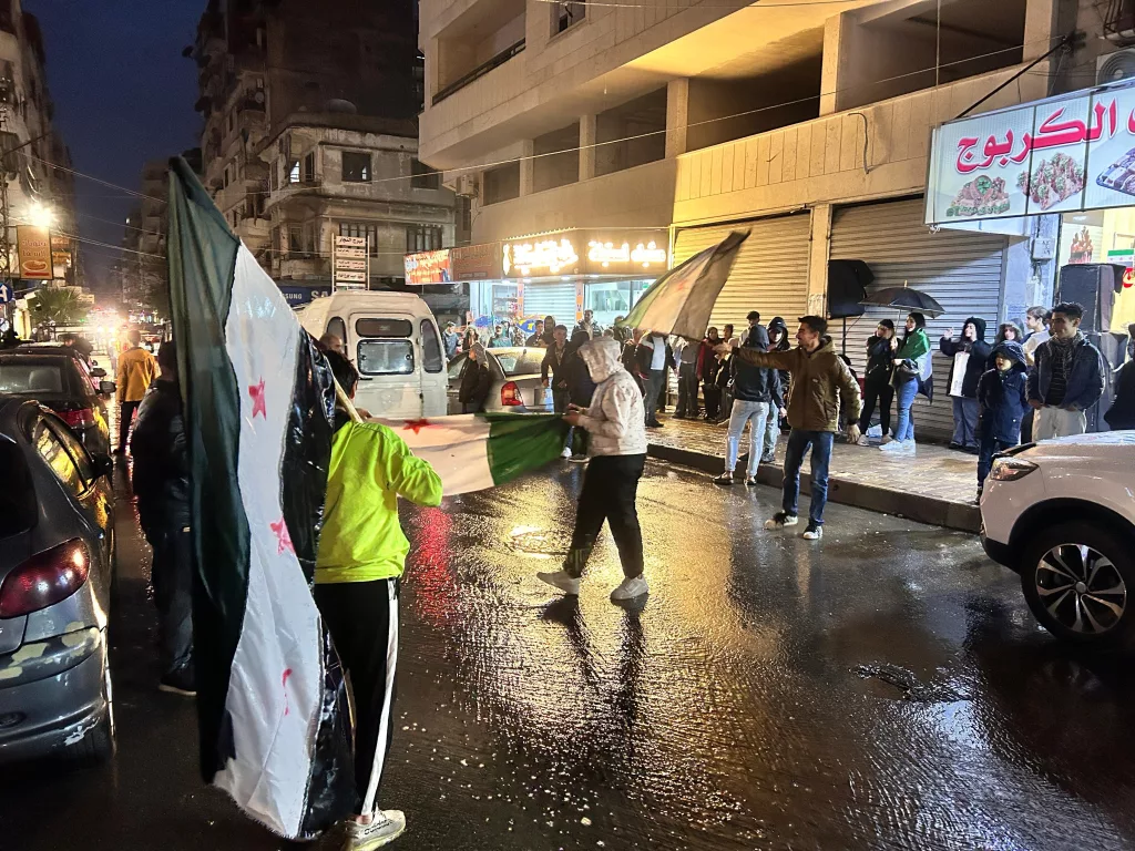 LAZKİYE'DE YAĞMURA RAĞMEN ESAD REJİMİNİN DEVRİLMESİ KUTLANDI