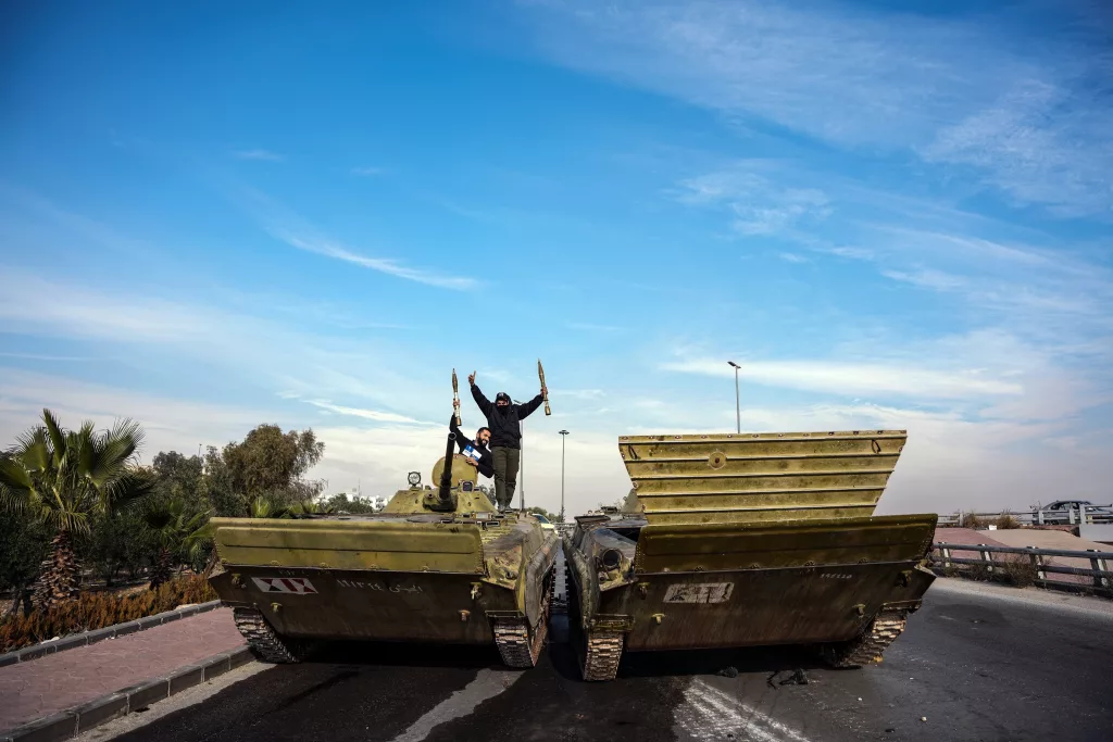 SURİYELİLERDEN ESAD REJİMİNDEN GERİYE KALAN TANKLARIN ÜZERİNDE "ZAFER" POZU ŞAM'DA HALK, TANKLARIN ÜZERİNDE ÖZGÜRLÜĞÜ KUTLUYOR