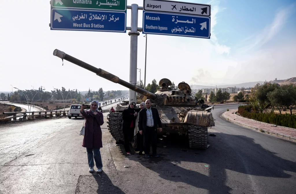 SURİYELİLERDEN ESAD REJİMİNDEN GERİYE KALAN TANKLARIN ÜZERİNDE "ZAFER" POZU ŞAM'DA HALK, TANKLARIN ÜZERİNDE ÖZGÜRLÜĞÜ KUTLUYOR