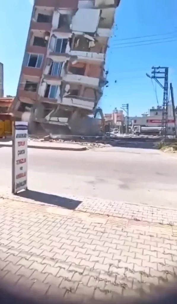 YIKIM ESNASINDA 7 KATLI BİNA İŞ MAKİNESİNİN ÜZERİNE DEVRİLDİ: O ANLAR KAMERADA